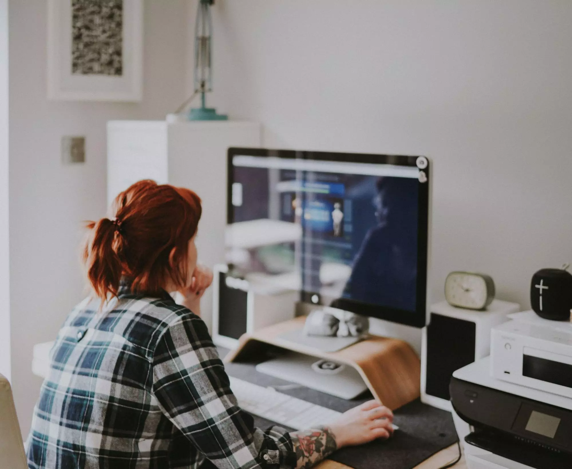 Image of a woman working on her computer. Post Best Practices to Manage Hybrid Teams.